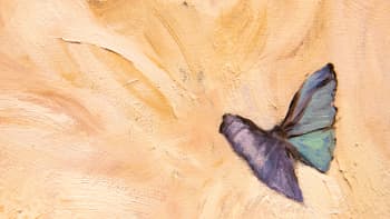 Closeup of a blue butterfly painted in oils on a cream background